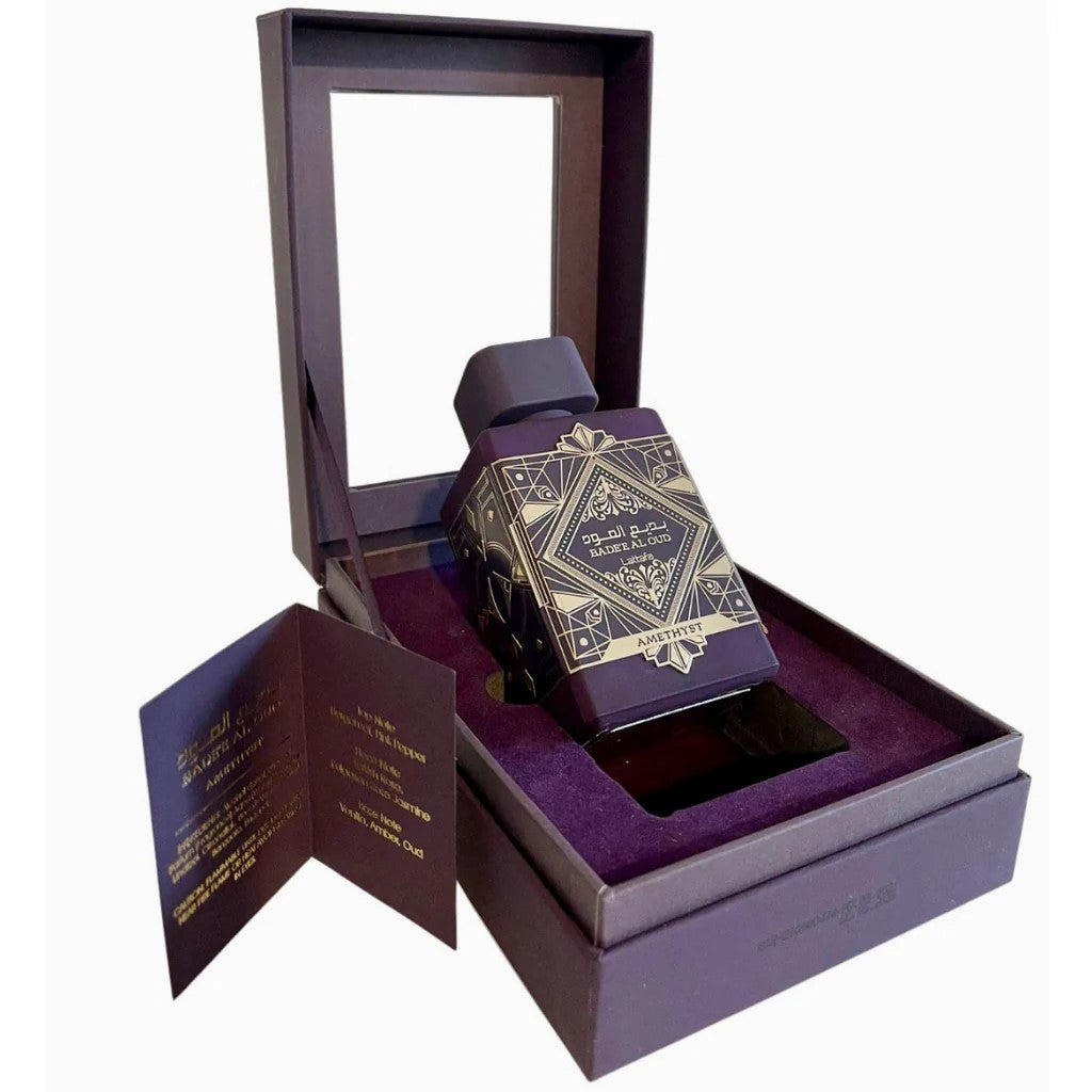 Purple perfume bottle with gold design in an open purple box on a white background