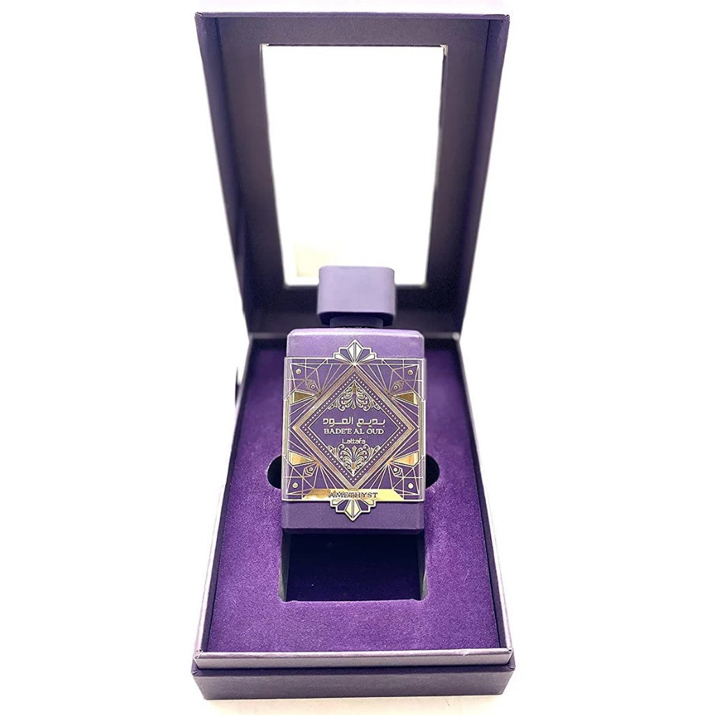 Purple perfume bottle with decorative design in a matching purple box on a white background