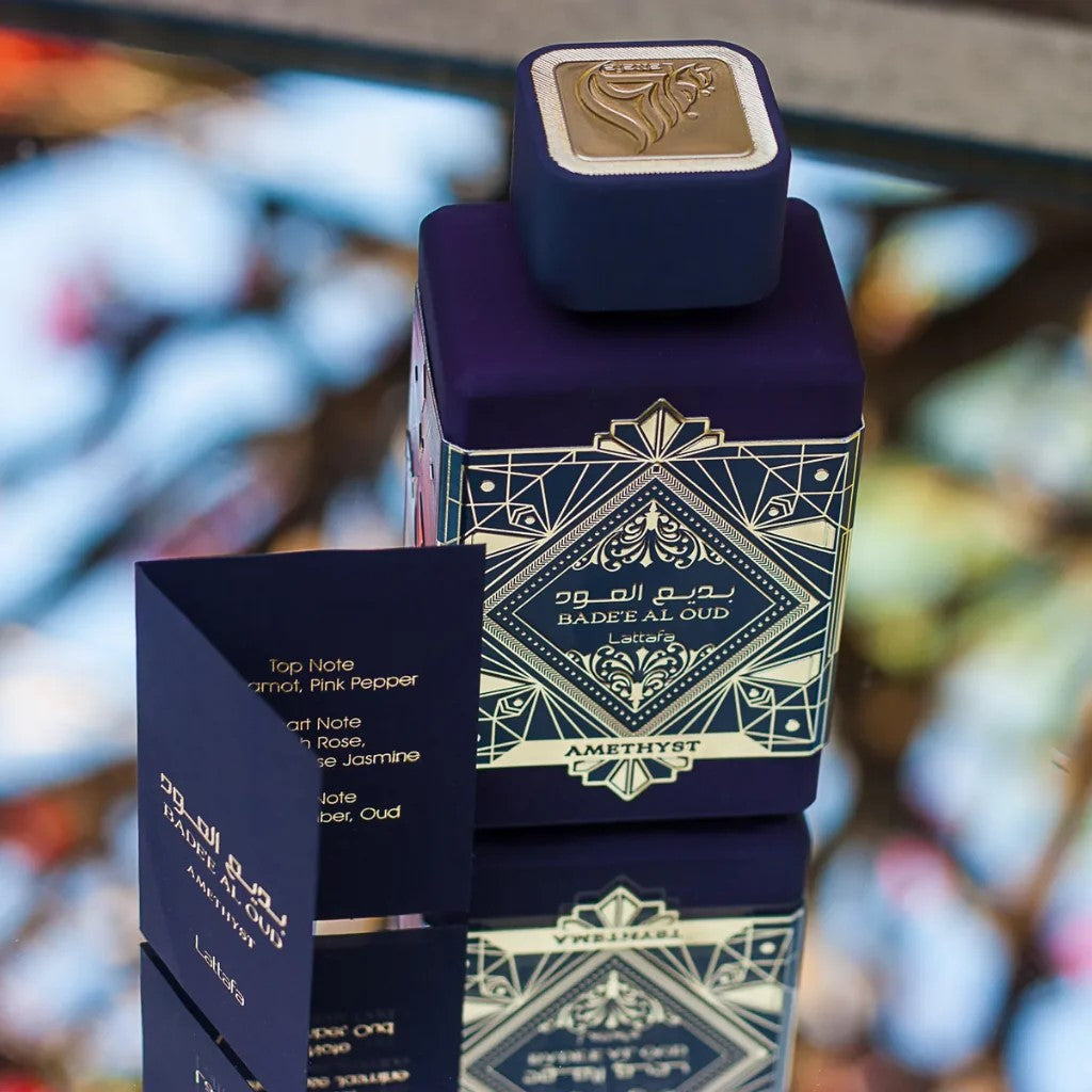 Blue and gold perfume bottle with packaging on a blurred background