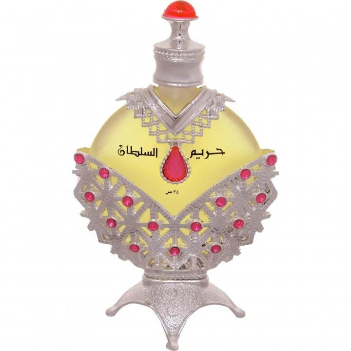 Decorative perfume bottle with intricate design and red accents on a white background